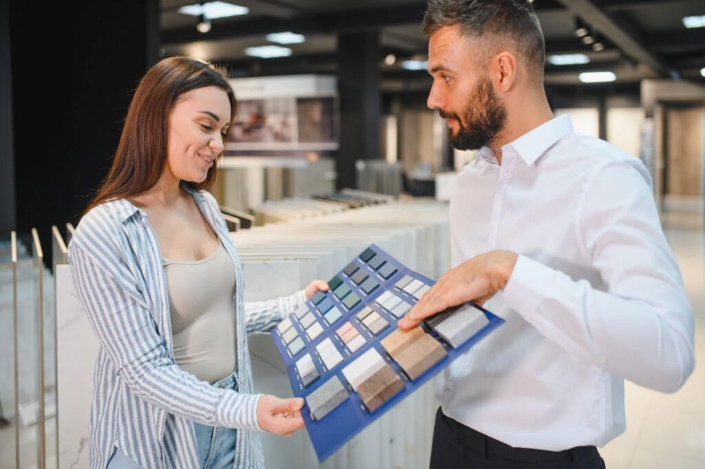 Specialist helping a homeowner choose pavers and stone samples.